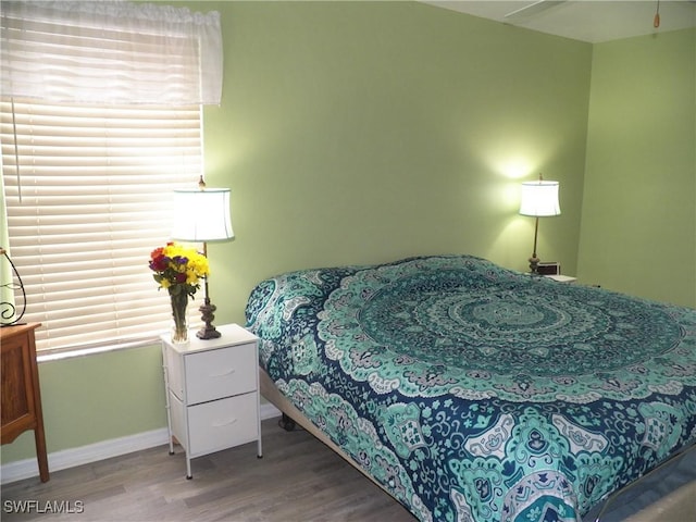 bedroom featuring multiple windows and hardwood / wood-style floors