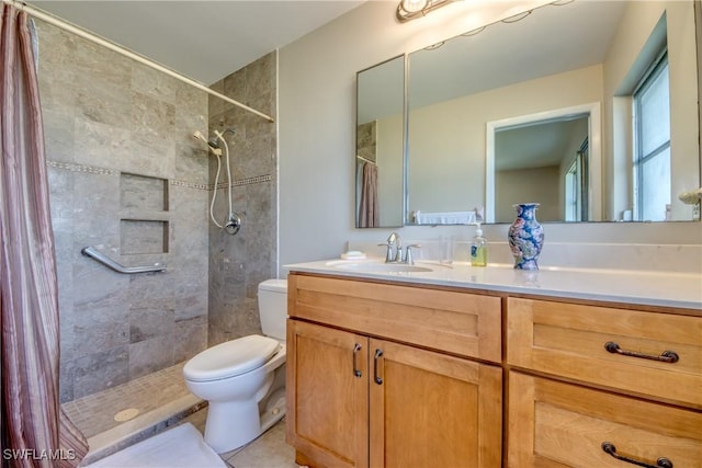 bathroom featuring vanity, walk in shower, and toilet