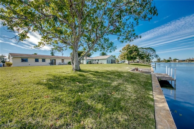 view of yard with a boat dock and a water view