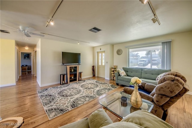 living room with ceiling fan, track lighting, and light hardwood / wood-style flooring