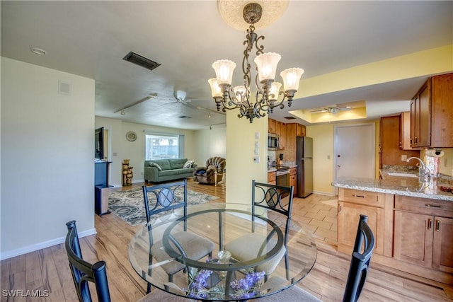 dining area featuring sink, ceiling fan, and light hardwood / wood-style floors