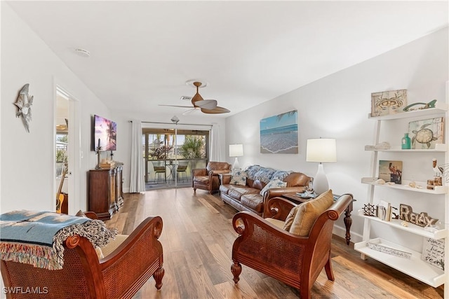 living room featuring wood-type flooring and ceiling fan