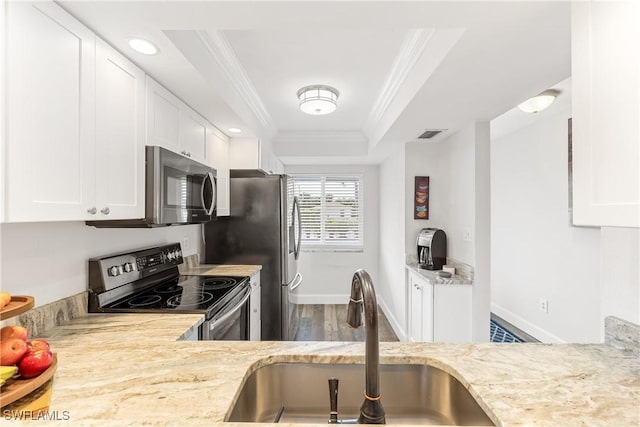 kitchen featuring white cabinets, range with electric cooktop, sink, and a tray ceiling