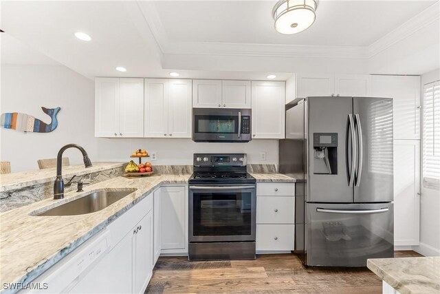 kitchen featuring hardwood / wood-style floors, sink, light stone countertops, stainless steel appliances, and white cabinets