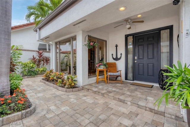 view of exterior entry with ceiling fan