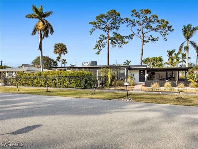 ranch-style home featuring a front lawn and a carport