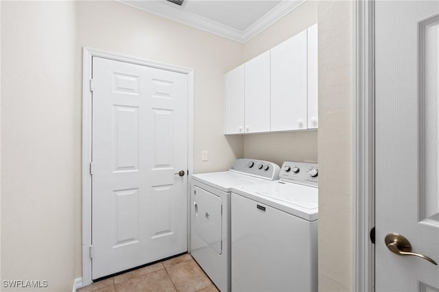 laundry area with cabinets, light tile patterned floors, crown molding, and washing machine and dryer