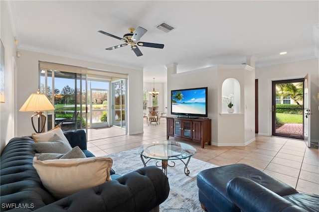 living room featuring light tile patterned floors, ceiling fan with notable chandelier, and ornamental molding