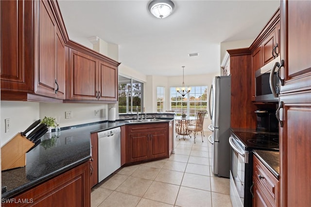 kitchen with appliances with stainless steel finishes, sink, hanging light fixtures, a notable chandelier, and light tile patterned floors