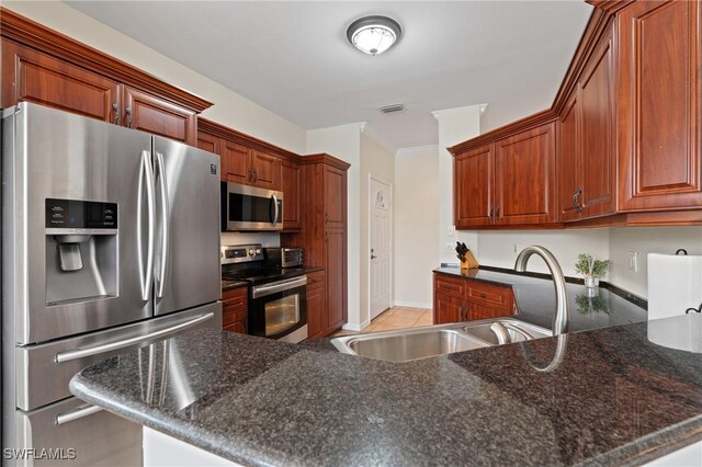 kitchen featuring dark stone countertops, kitchen peninsula, sink, a kitchen breakfast bar, and stainless steel appliances