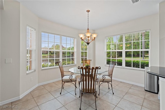 dining room with light tile patterned floors and a chandelier