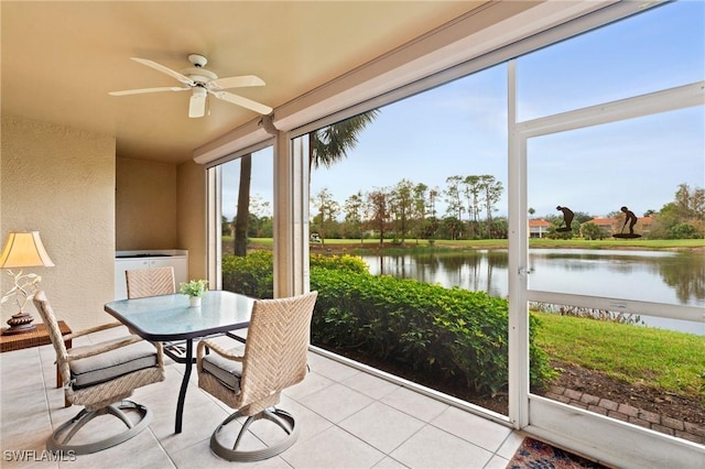 sunroom / solarium featuring ceiling fan and a water view