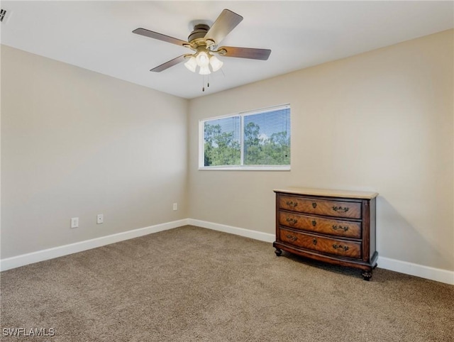 carpeted spare room with ceiling fan