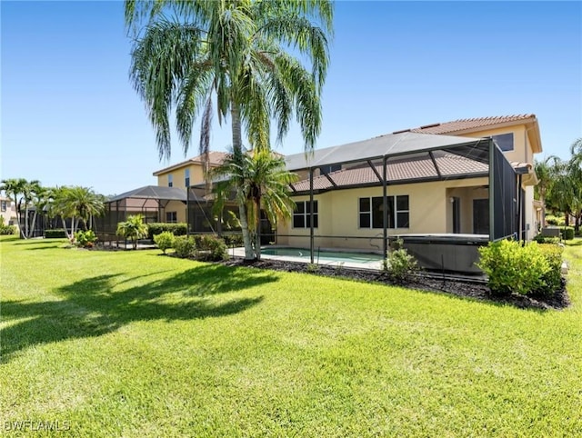 back of property with glass enclosure and a lawn