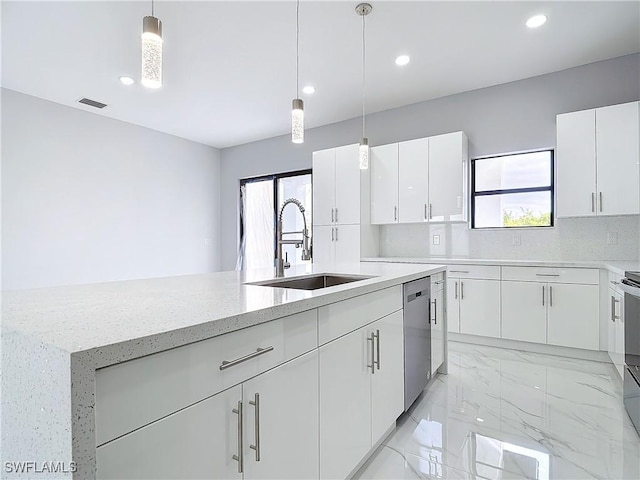 kitchen with sink, hanging light fixtures, and white cabinets