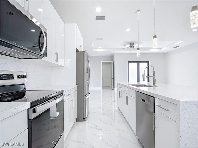 kitchen featuring pendant lighting, white cabinetry, appliances with stainless steel finishes, and sink