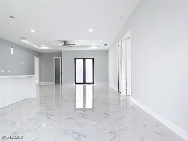 unfurnished room with french doors, ceiling fan, and a raised ceiling