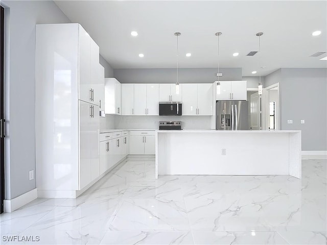 kitchen featuring white cabinetry, decorative light fixtures, a center island, and appliances with stainless steel finishes