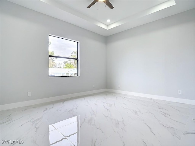 spare room featuring ceiling fan and a tray ceiling