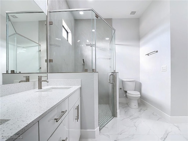 bathroom with toilet, vanity, and a shower with shower door