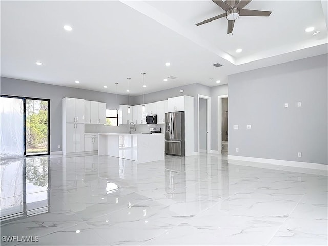 kitchen featuring stainless steel appliances, a center island, hanging light fixtures, and white cabinets