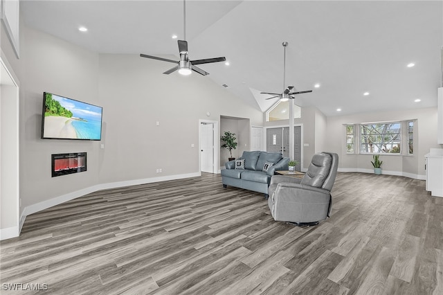 living room featuring ceiling fan, light hardwood / wood-style floors, and high vaulted ceiling