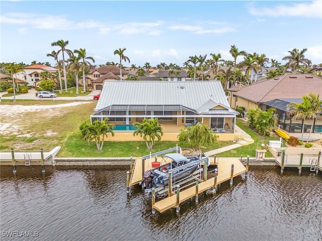 dock area with glass enclosure, a yard, and a water view