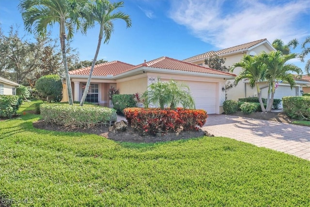 mediterranean / spanish home featuring decorative driveway, stucco siding, a garage, a tiled roof, and a front lawn