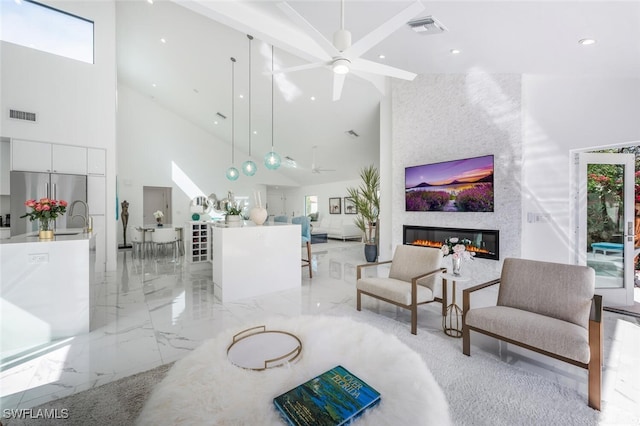 living room with a fireplace, high vaulted ceiling, and ceiling fan