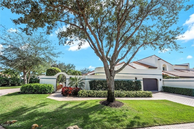 view of front of house featuring a garage and a front lawn