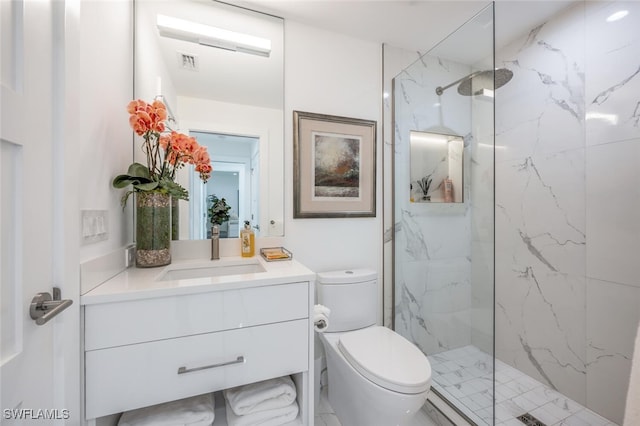 bathroom with vanity, toilet, and a tile shower