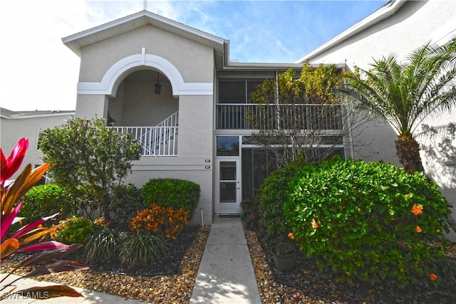 view of exterior entry featuring a balcony