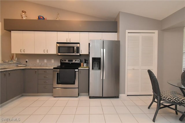 kitchen with vaulted ceiling, appliances with stainless steel finishes, gray cabinetry, and white cabinets