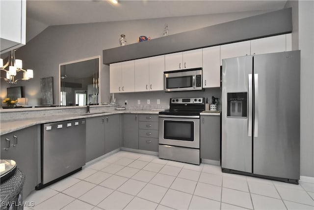 kitchen with lofted ceiling, appliances with stainless steel finishes, gray cabinetry, and white cabinets