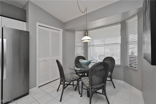 tiled dining room with vaulted ceiling