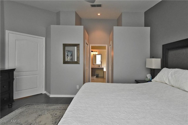 bedroom featuring ensuite bathroom and a towering ceiling