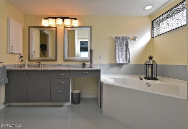 bathroom featuring a bathtub, vanity, and tile patterned flooring