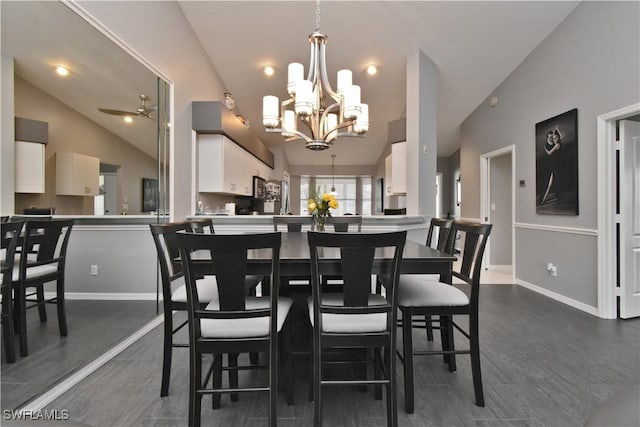 dining room featuring ceiling fan with notable chandelier and lofted ceiling