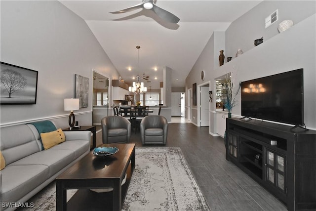 living room with ceiling fan with notable chandelier and high vaulted ceiling