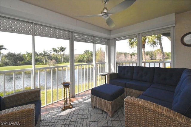 sunroom / solarium with ceiling fan, a wealth of natural light, and a water view