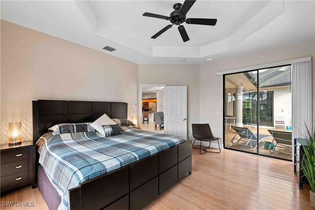 106 SE 5th St, Cape Coral, FL 33990 - bedroom featuring a raised ceiling, access to outside, light wood-type flooring, and ceiling fan