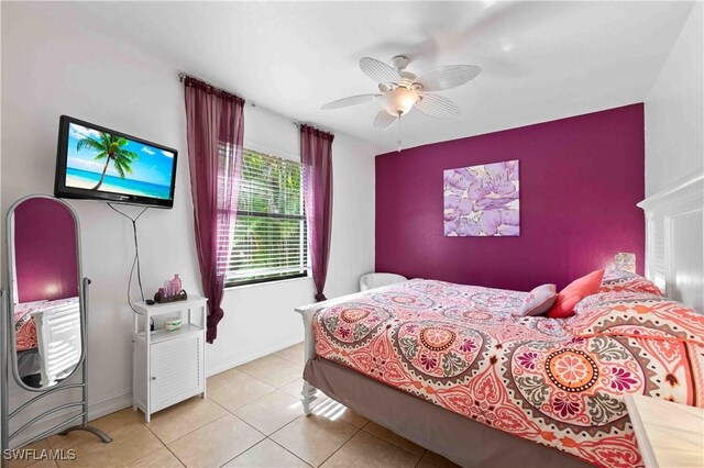 106 SE 5th St, Cape Coral, FL 33990 - bedroom with light tile patterned floors, baseboards, a ceiling fan, and an accent wall