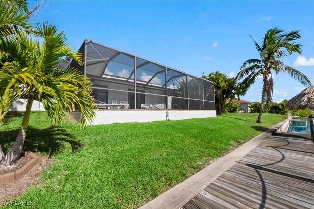 106 SE 5th St, Cape Coral, FL 33990 - view of grassy yard featuring glass enclosure and an outdoor pool