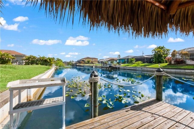 106 SE 5th St, Cape Coral, FL 33990 - dock with a water view, a residential view, and a lawn