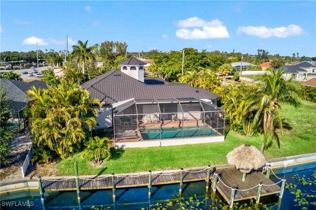 106 SE 5th St, Cape Coral, FL 33990 - back of house featuring a tile roof, an outdoor pool, a patio area, and a lawn