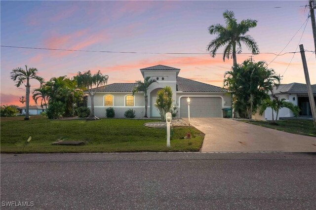 106 SE 5th St, Cape Coral, FL 33990 - mediterranean / spanish-style home featuring an attached garage, concrete driveway, a front yard, stucco siding, and a tile roof