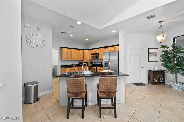 106 SE 5th St, Cape Coral, FL 33990 - kitchen with appliances with stainless steel finishes, light tile patterned floors, dark countertops, a sink, and a center island with sink