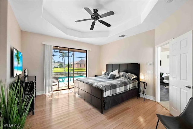 106 SE 5th St, Cape Coral, FL 33990 - bedroom featuring a raised ceiling, access to exterior, light wood finished floors, baseboards, and a ceiling fan