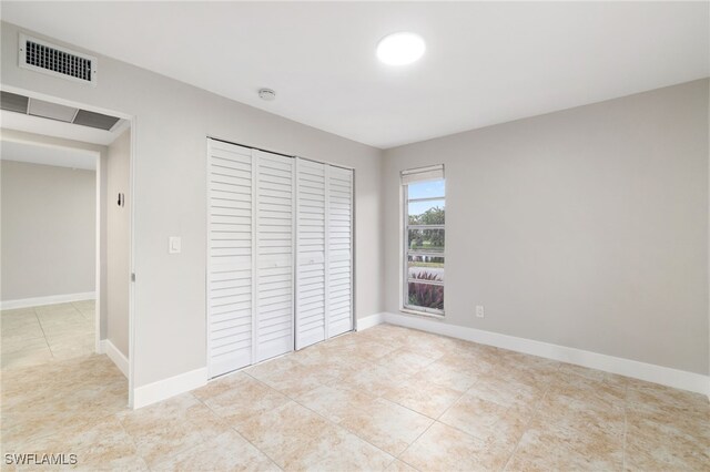 unfurnished bedroom with light tile patterned floors and a closet