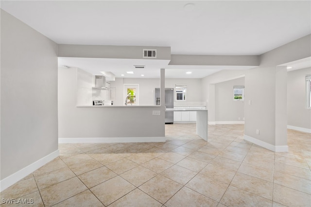 interior space with white cabinetry, stainless steel fridge with ice dispenser, light tile patterned floors, and exhaust hood